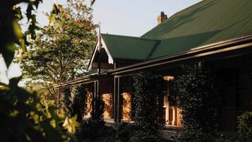 A brick building with a green roof and a covered porch.