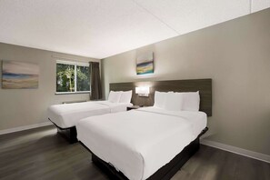 A hotel room with two beds, a large window, and artwork on the walls. - Suburban Studios Milwaukee Airport (Milwaukee)