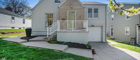 A two-story house with a front porch, a garage, and a well-maintained lawn.