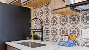 Una cocina con un lavamanos doble, un grifo moderno y un salpicadero decorativo.