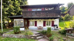 A wooden house with a balcony, a barbecue area, and a small garden. - Cozy 2BR Apartment with Mountainview* Free Parking (Flums)