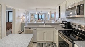 Una cocina moderna con una isla central, electrodomésticos integrados y vistas al área de estar.