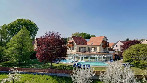 A large house with a swimming pool and a covered patio area.
