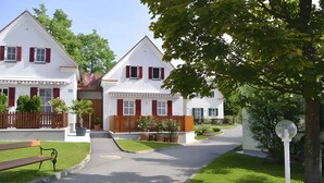 A two-story house with a front yard, a bench, and a street lamp.
