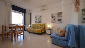 A compact living space with a dining area, a sofa, and a small table.
