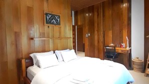 A large bed with white linens in a room with wooden walls and ceiling. - Stay Kultura (Banda Aceh)