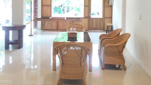 A spacious lobby with a high ceiling, wooden paneling, and a glass-top table. - Stay Kultura (Banda Aceh)