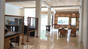 A spacious lobby with high ceilings, wooden paneling, and a polished floor. There are several seating areas with chairs and tables, and large windows allowing natural light. - Stay Kultura (Banda Aceh)