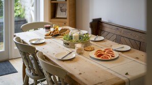Uma mesa de jantar posta com pratos, talheres e alimentos.