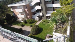A multi-story building with balconies, a garden area, and a pool. - Holiday apartment mit Klimaanlage und Balkon (Bibione)