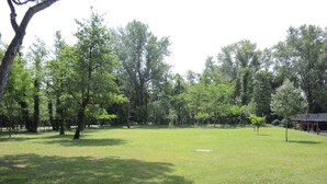 A park with trees, grass, and a paved path. - Holiday apartment mit Klimaanlage und Balkon (Bibione)