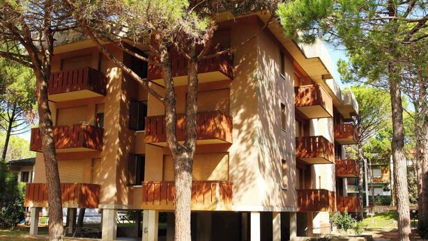 A multi-story building with balconies, surrounded by trees. - Holiday apartment mit Klimaanlage und Balkon (Bibione)