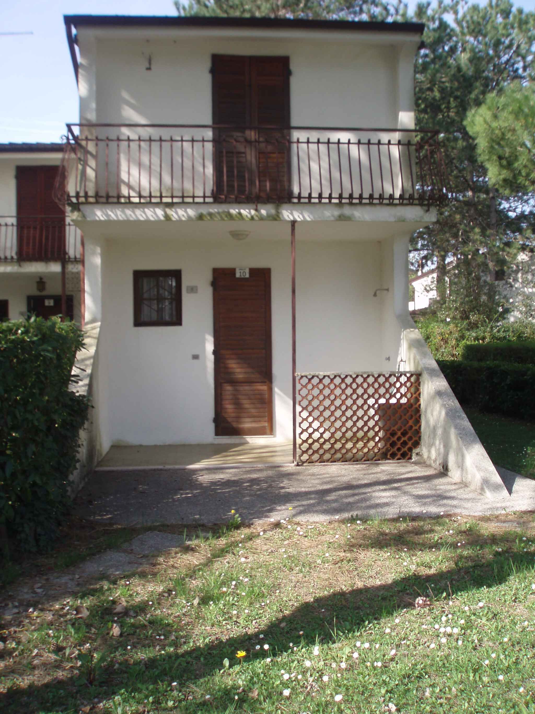 Un bâtiment à deux étages doté d’un balcon, d’une porte et d’une petite fenêtre.