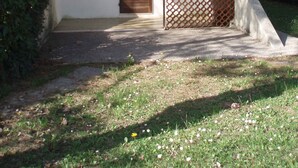 Un edificio de dos pisos con un balcón, una puerta y un ventanal pequeño.