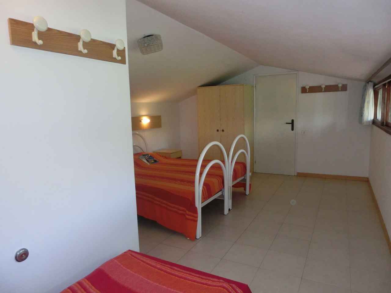 Une chambre à coucher avec un lit, une armoire et une petite table.