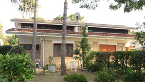 Un bâtiment à deux étages, doté d’un toit recouvert de tuiles, d’une antenne parabolique et d’une porte de garage.