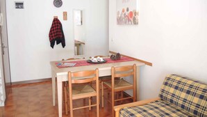 Un comedor con mesa, sillas y un sofá.