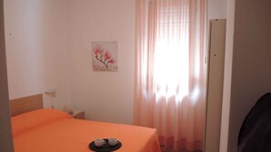 Una habitación con una cama, un cuadro en la pared y una puerta.