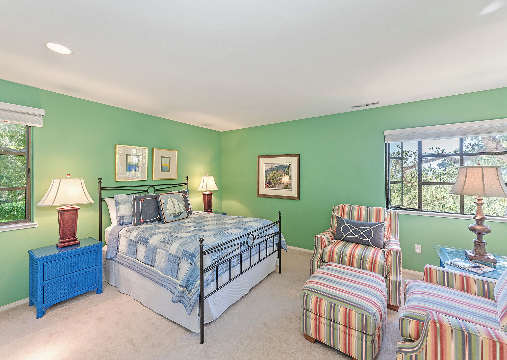 A bedroom with a bed, two bedside tables, a chair, and a window.