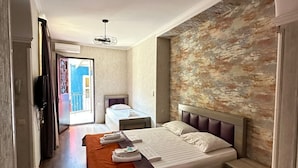A modern bedroom with a large bed, a wooden headboard, and a view of the outside. - Hotel Piano (Tbilisi)