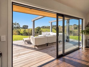 A modern living room with a large sliding glass door leading to an outdoor deck.