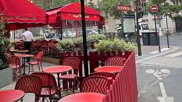 An outdoor café with red umbrellas and wicker furniture. - National Assembly Orsay Museum (Paris)