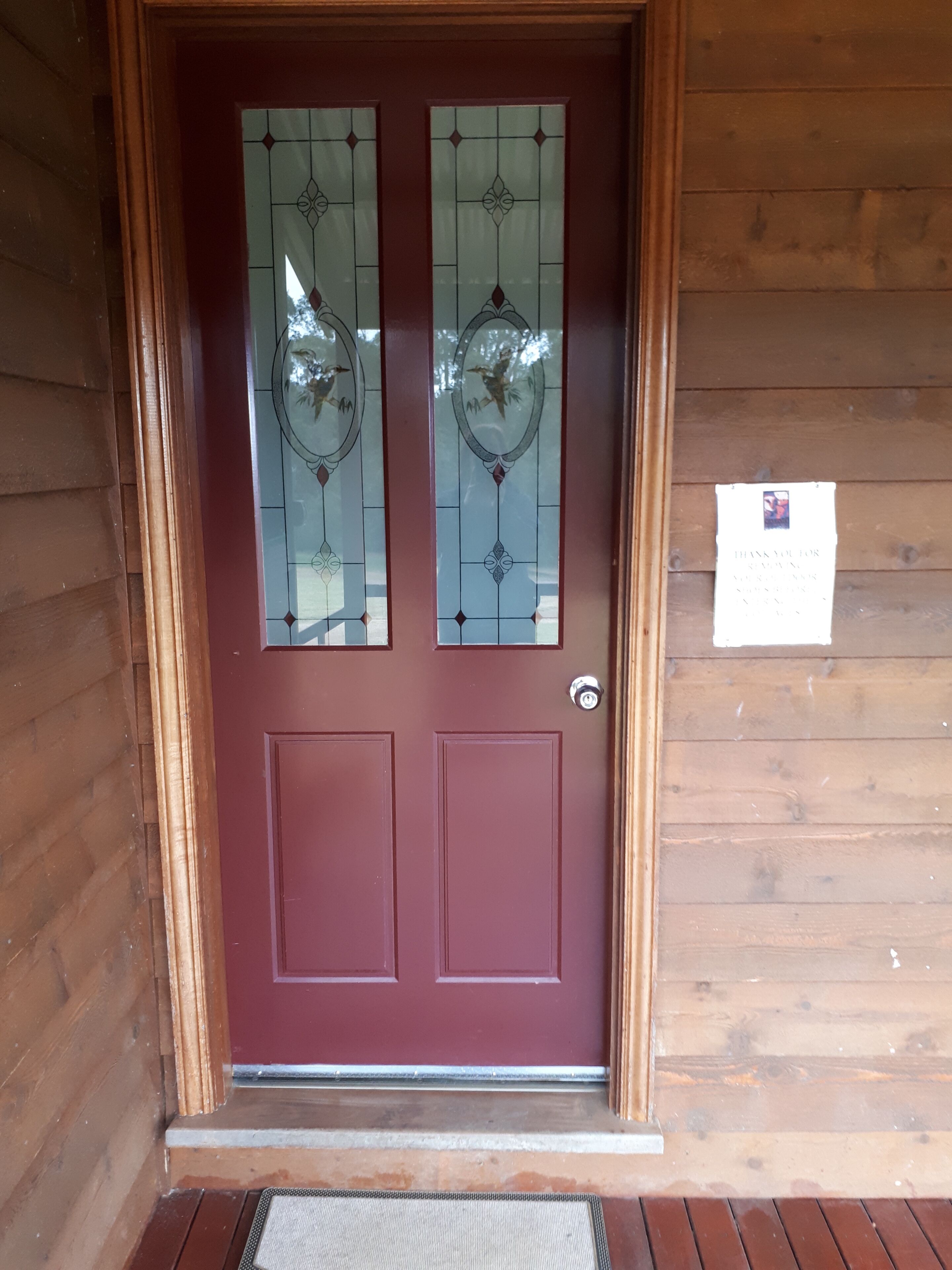 Una porta in legno con pannello rosso e vetrate decorative.