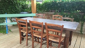 Eine Holzterrasse mit Tisch und Stühlen.