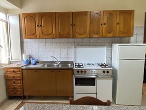 Frigorífico, placa de cocina, utensilios de cocina y mesa de comedor