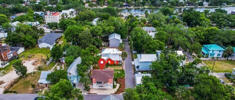 An aerial view of a residential area with houses, trees, and a marina in the background.
