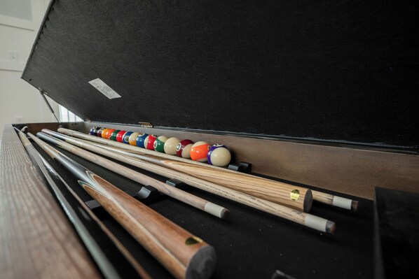 Une table de billard avec des queues et des billes.