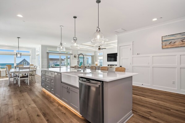 A modern kitchen with a central island, stainless steel appliances, and pendant lighting. - Slow M'Ocean: Large, Modern Home with a Pool, Elevator and Hot Tub! (Oak Island)