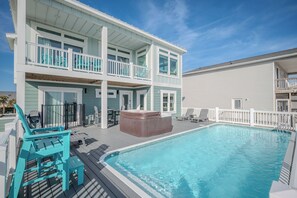 Een gebouw met twee verdiepingen, een zwembad, terras en een jacuzzi.