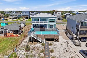 A two-story house with a large deck and a swimming pool. - Slow M'Ocean: Large, Modern Home with a Pool, Elevator and Hot Tub! (Oak Island)