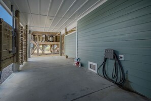 A building under construction with exposed wooden framing, a concrete floor, and a green exterior wall. - Slow M'Ocean: Large, Modern Home with a Pool, Elevator and Hot Tub! (Oak Island)