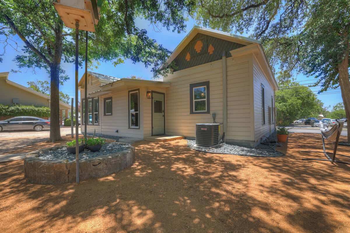 A single-story house with a front porch, a small garden area, and a clear driveway.