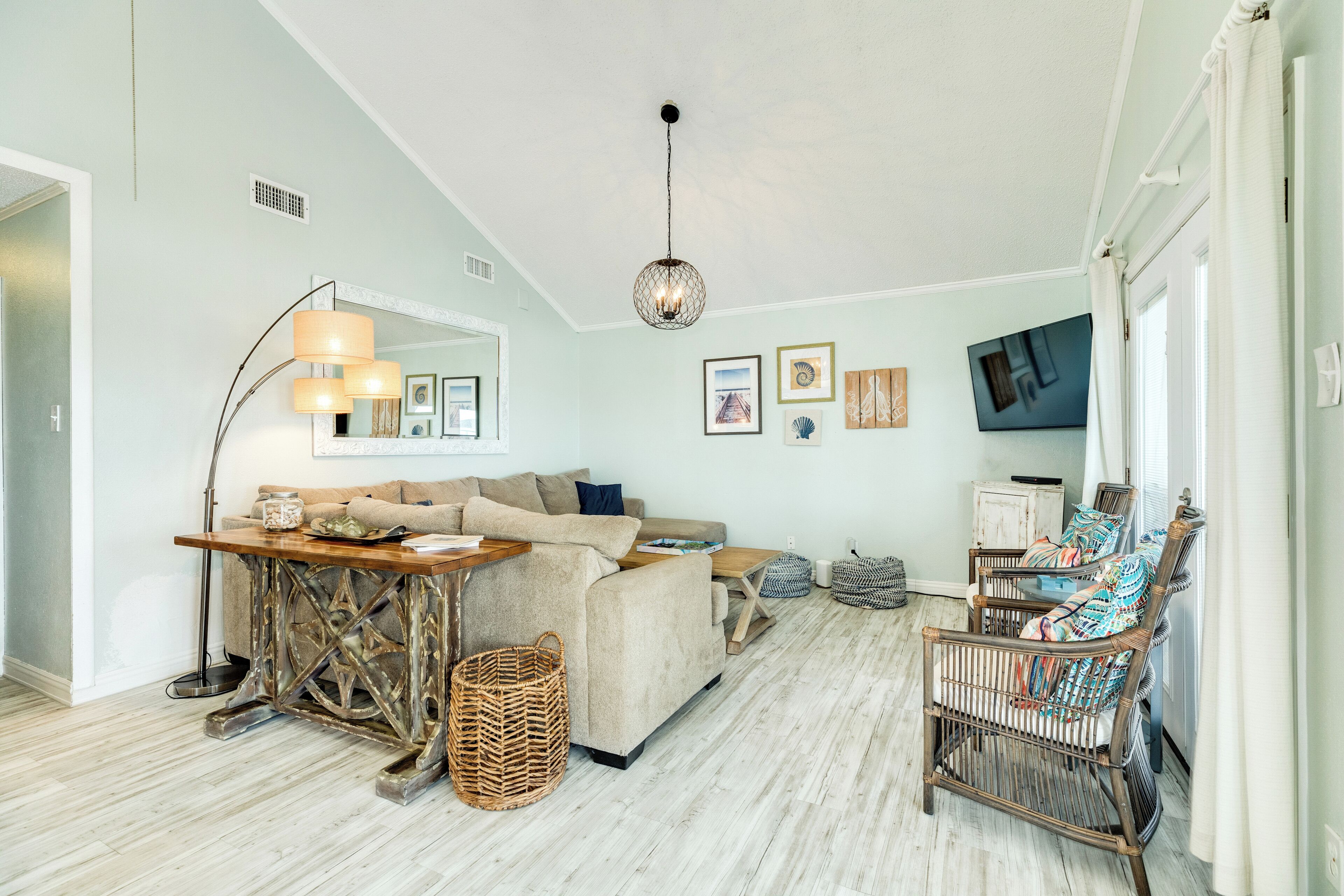 A cozy living room with a sofa, a coffee table, a TV, and a wicker basket.