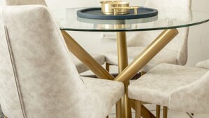 A dining area with a glass table, gold legs, and white chairs. - Seaside Studio on Isla Verde Beach (Carolina)