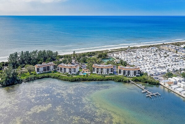 An aerial view of a coastal hotel with multiple buildings, a marina, and a beach.