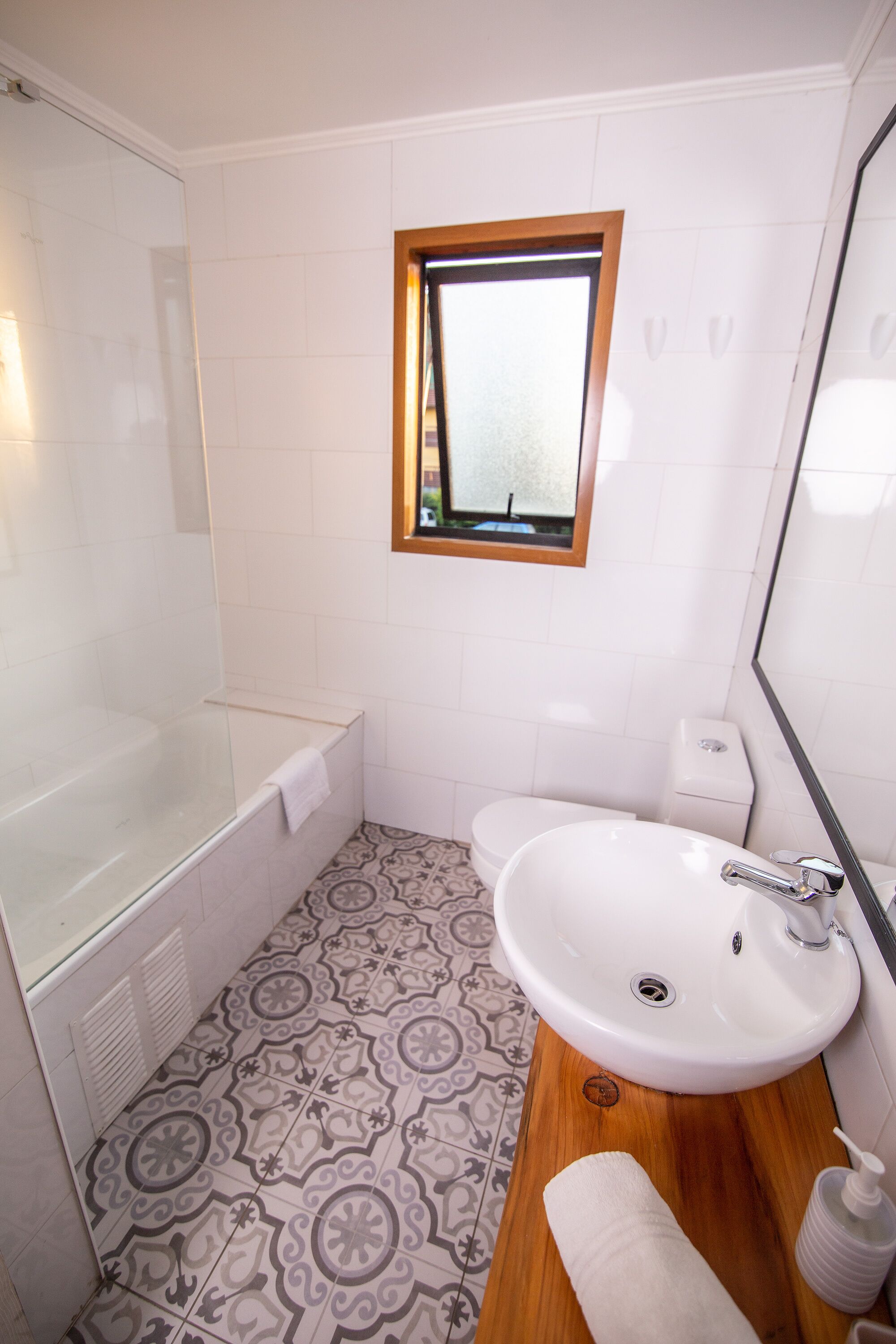 Een badkamer met een bad, een wastafel en een raam.