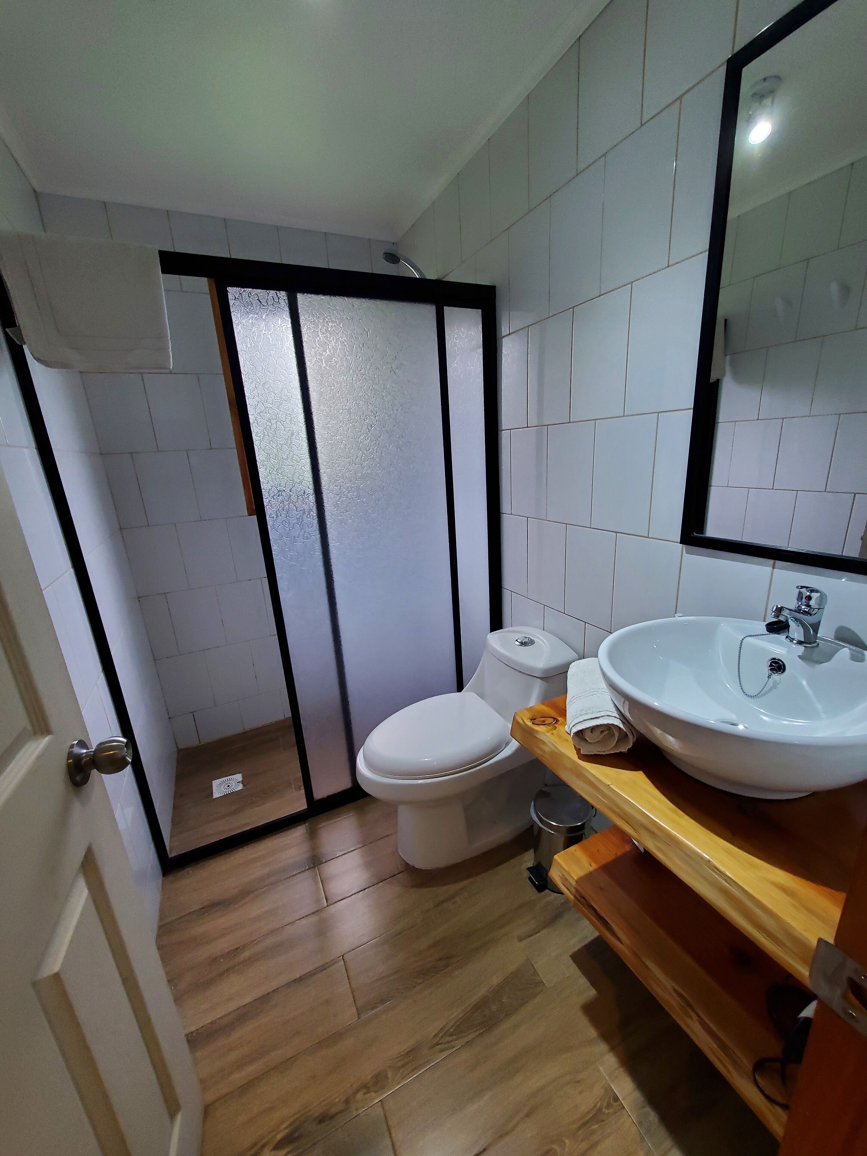 Un baño con inodoro, lavabo y zona de ducha.