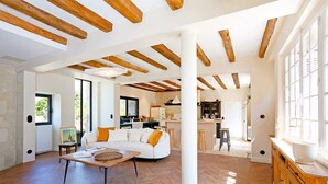 A spacious living area with a white sofa, wooden beams, and a herringbone floor. - La maison Berry (Vouvray)