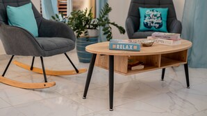 A room with two grey armchairs, a wooden coffee table with a 'RELAX' sign, and a potted plant. - Villa Belle Mar with a pool and within walking distance of the beach!  (Puerto Plata)