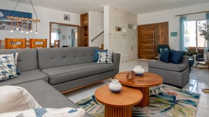 A modern living room with a grey sectional sofa, two round wooden coffee tables, and a patterned rug. - Villa Belle Mar with a pool and within walking distance of the beach!  (Puerto Plata)