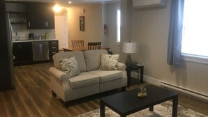 Ein Wohnzimmer mit einer Couch, einem Couchtisch und einem Essbereich mit Stühlen und einem Tisch.