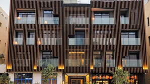 A modern building with a symmetrical facade, multiple windows, and a central entrance. - Tajreed Hotel (Riyadh)