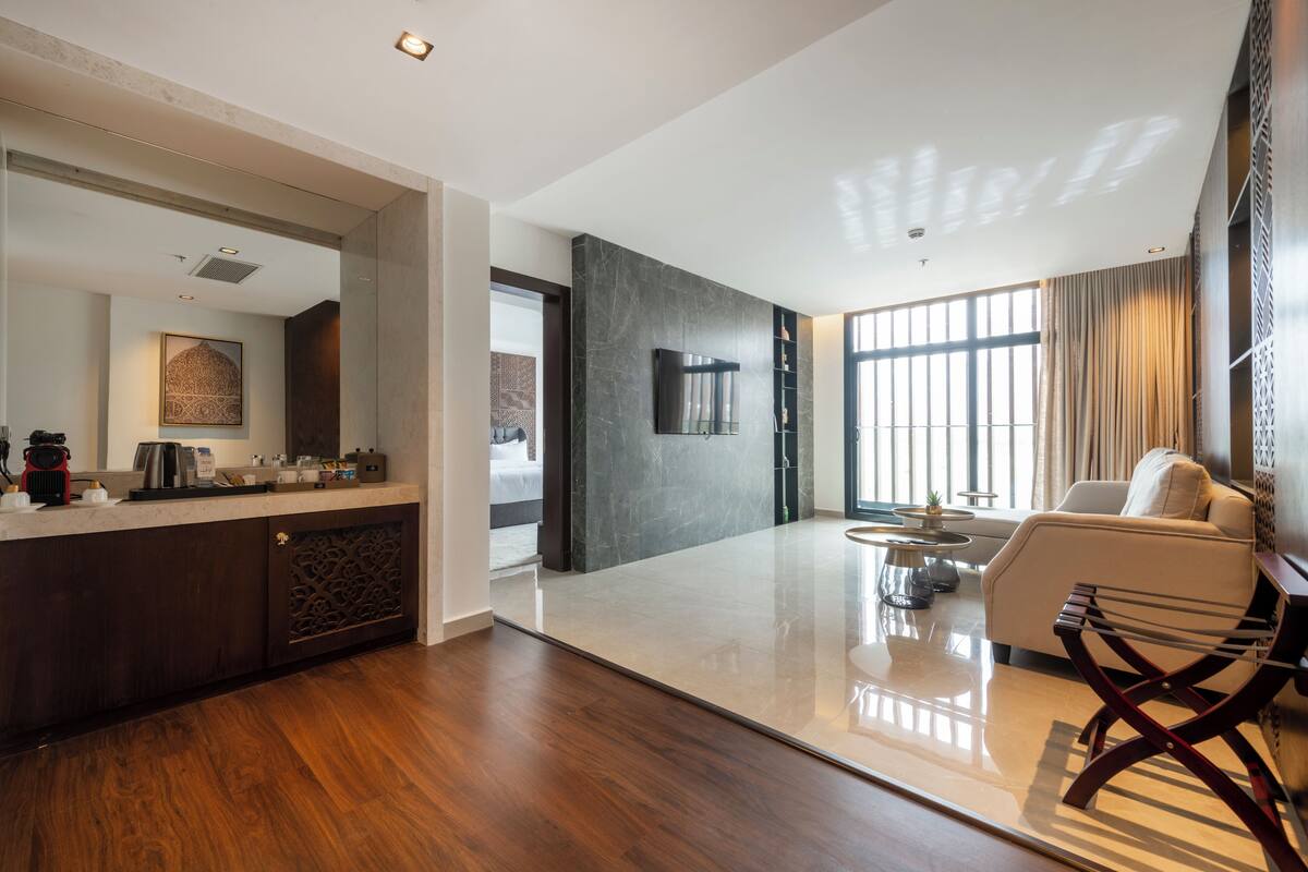 A spacious living area with a modern design, featuring a large flat-screen TV, a comfortable sofa, and a coffee table.