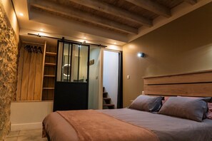 Ein Schlafzimmer mit Bett, Holz-Kopfteil und einer Schiebetür zum Kleiderschrank.
