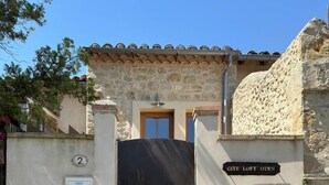 Ein Gebäude mit einer Stein-Fassade, einem schwarzen Tor und einem Schild mit der Aufschrift 'CITE LOFT OVEN'.