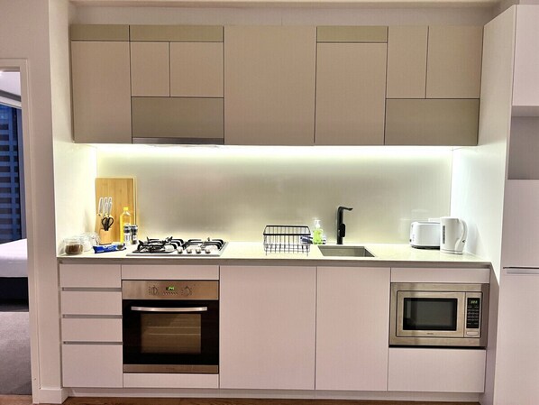 A modern kitchen with a built-in oven, microwave, and gas stove.